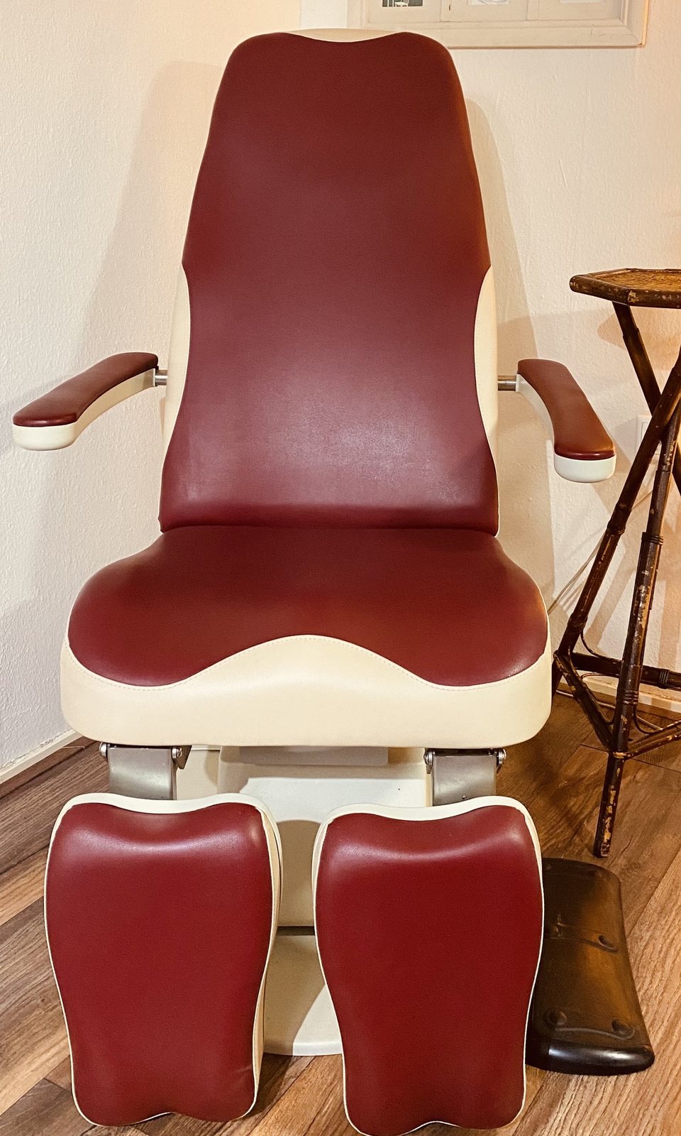 De rode behandelstoel van Pedicure Rabia met een houten bijzettafel